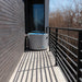 Revive Inflatable Pod Plunge Ice Bath Tub filled with water in a narrow passage between a brick wall and railing