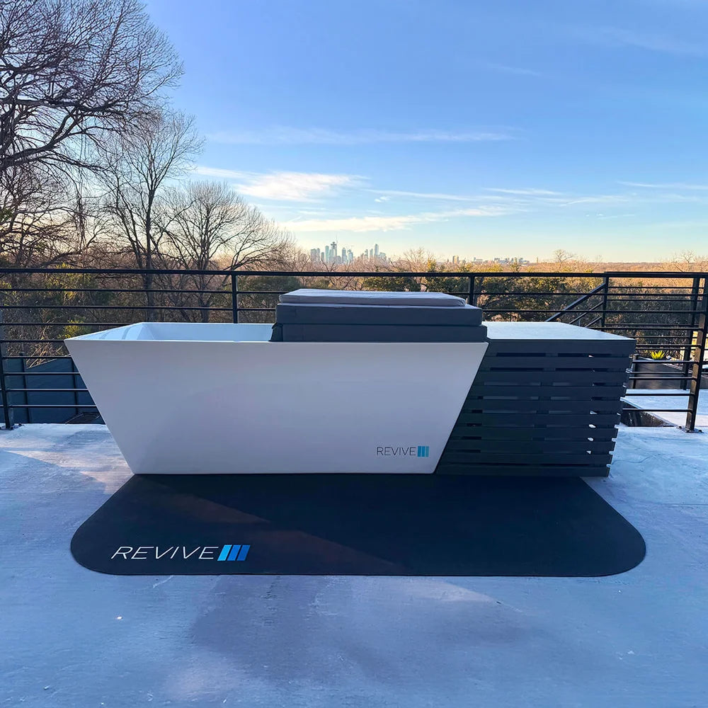 Revive Cold Plunge Chiller Cover lined up flush with an open white acrylic plunge tub on a rooftop terrace