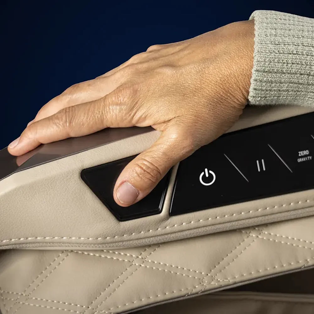 Thumb resting on the built-in health sensor pad of the Infinity Ultra Imperial Massage Chair cream armrest