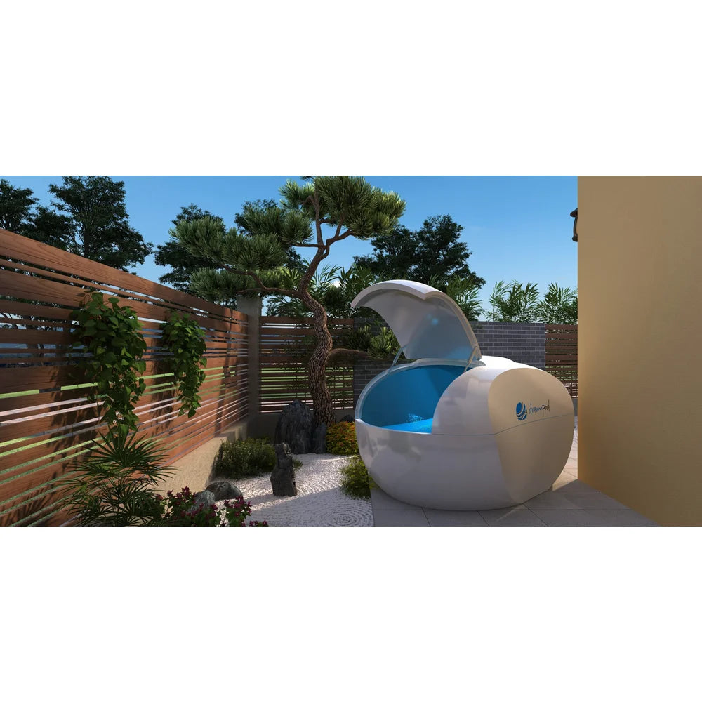 Dreampod Home Float Plus Sensory Deprivation Tank open on a paved terrace with wooden slat fencing