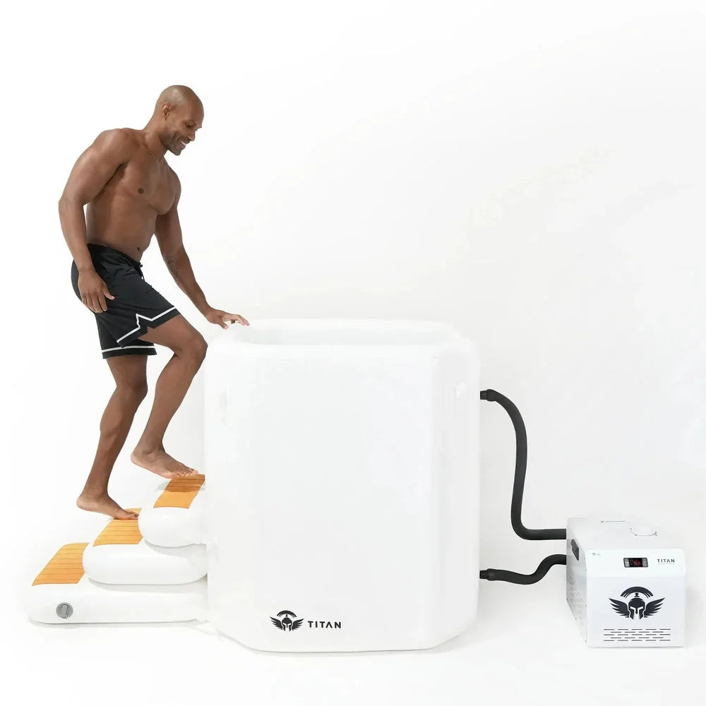 Man stepping onto the inflatable stairs of the Arctic White Titan Atlas tub with white chiller connected