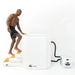 Man climbing the inflatable steps of the Arctic White Titan Atlas Ice Bath with the chiller hosed alongside