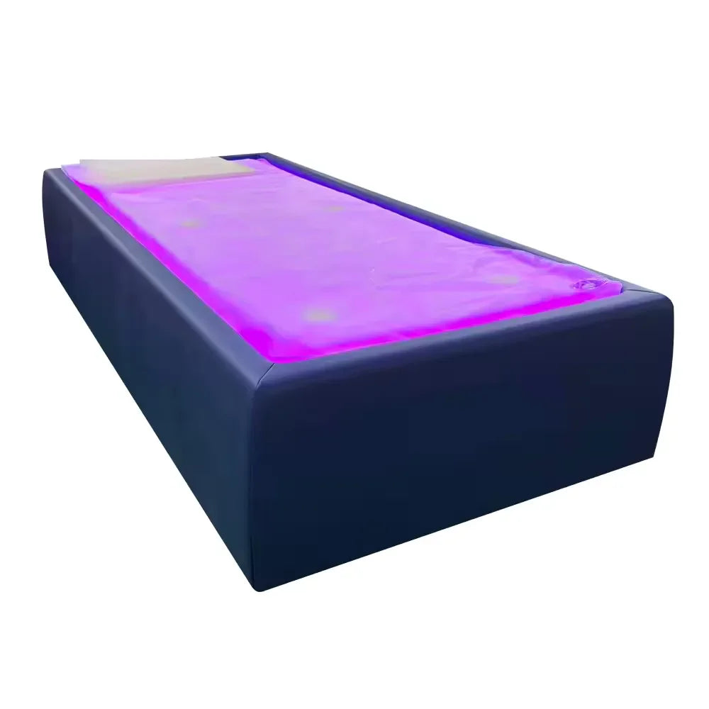 Navy blue Tsb360 Dry Float Recovery Bed angled on white with magenta-purple lit membrane and head pad