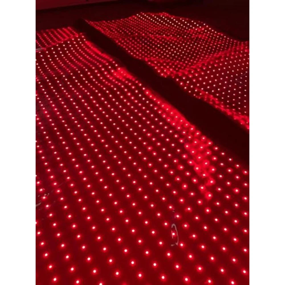 Two side-by-side lit panels with long red LED rows on the Kore KoreKapsule Near Infrared Light Therapy Device in the dark