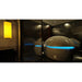 Two pods in a dark spa lounge with a bright blue door light band, the Dreampod Vmax Isolation Pod mirrored in glass