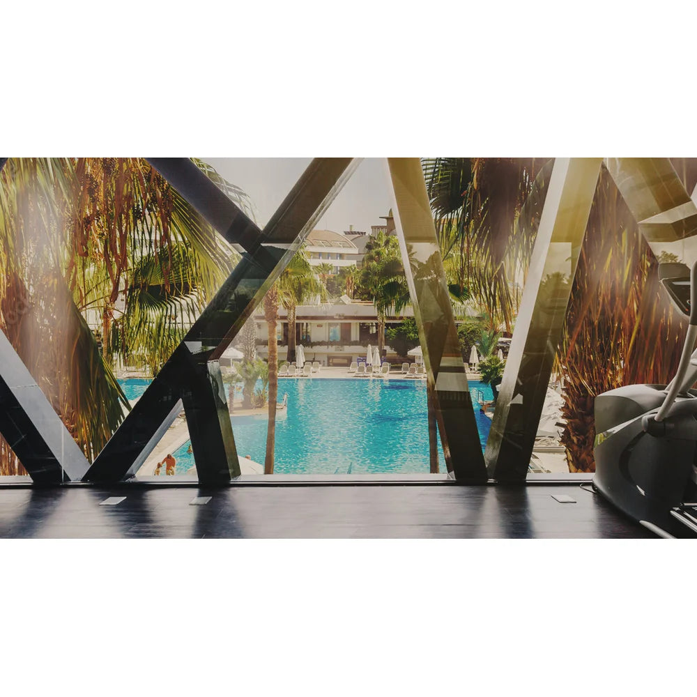 Hotel gym overlooking a resort pool, a hospitality venue suited to the Vacu Activ Cryo Flow Cryotherapy Device