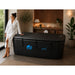 Woman in a white robe resting a hand on the closed lid of the Dreampod Home Float FLEX in a spa-styled room